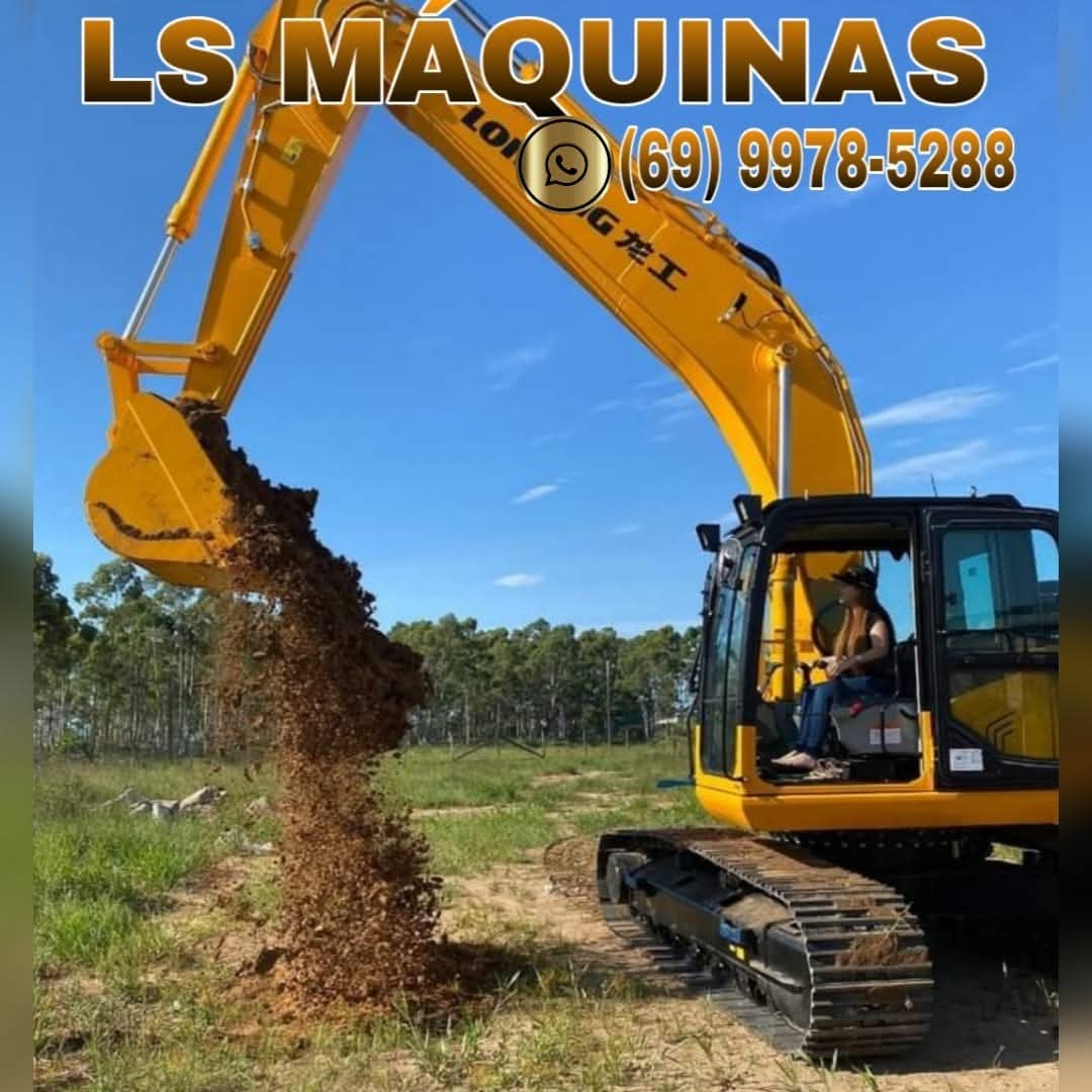 Escavadeira amarela escavando terra em campo aberto com operador dentro da cabine, sob céu azul com árvores ao